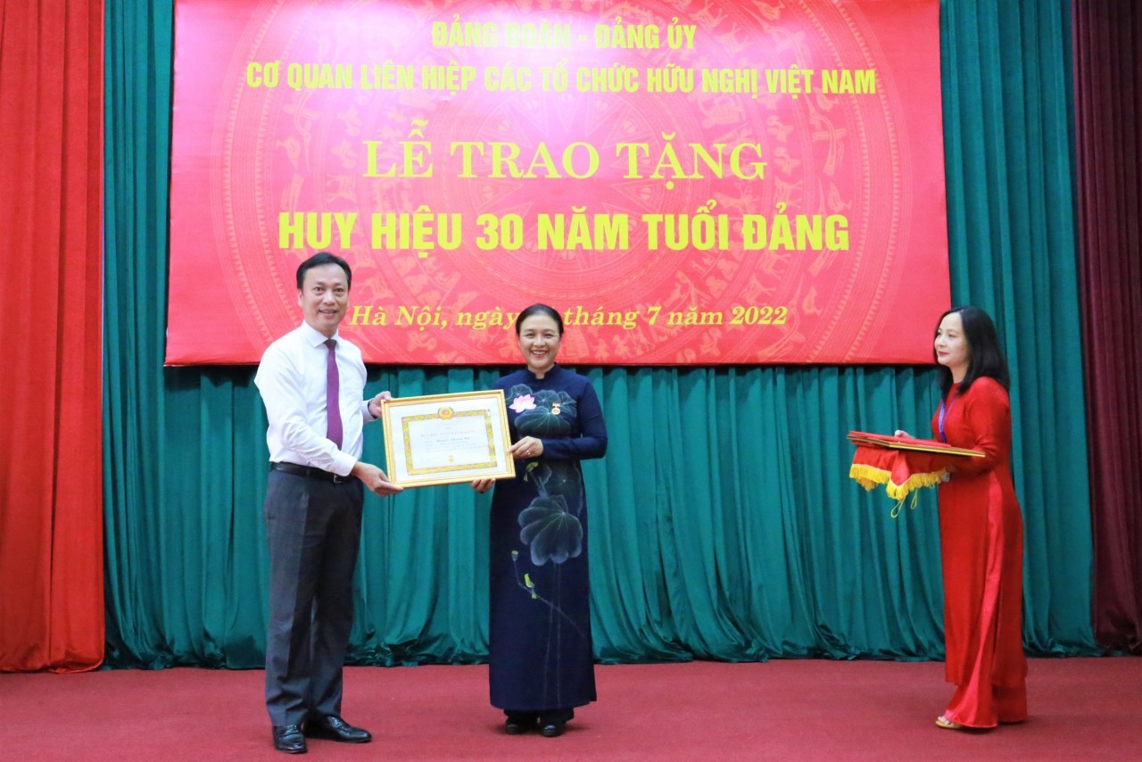 Ông Lại Xuân Lâm, Phó Bí thư Đảng ủy khối các cơ quan Trung ương, trao huy hiệu 30 năm tuổi Đảng cho bà Nguyễn Phương Nga - Bí thư Đảng đoàn, Chủ tịch Liên hiệp các tổ chức hữu nghị Việt Nam. Ảnh: Hải An.