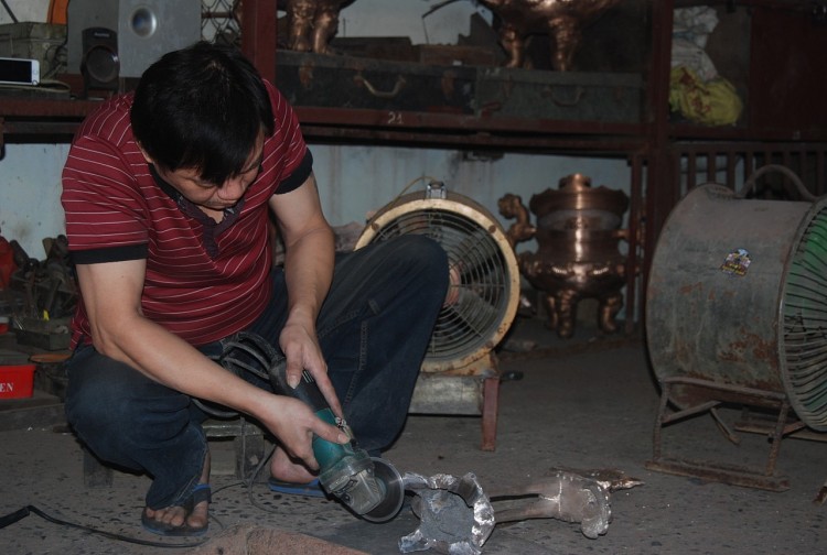 Người thợ đang làm việc tại xưởng đúc đồng làng Ngũ Xã (Ảnh: Nhã Liên).