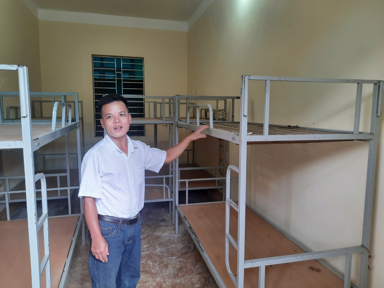 Thầy Lê Quốc Phòng dẫn phóng viên đi thăm khu phòng ở bán trú mới do Quân khu 2 hỗ trợ xây dựng.