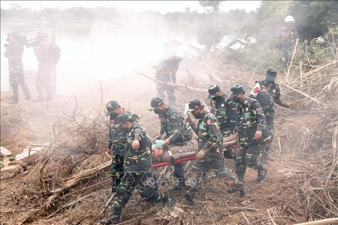 Các chiến sĩ đang đưa một người dân bị bùn, đất bị vùi lấp đi cấp cứu trong một tình huống giả định tại diễn tập (Ảnh: Phạm Kiên/Phóng viên TTXVN tại Lào)