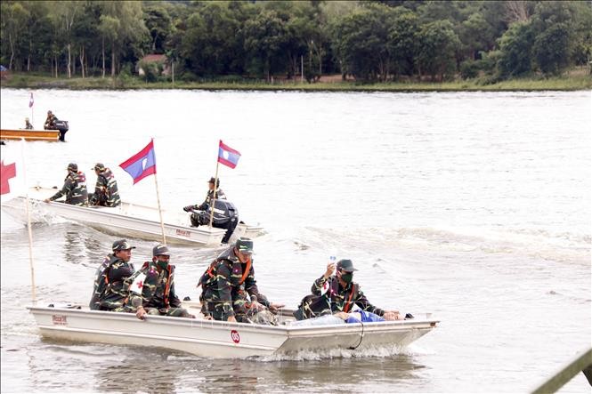 Các thuyền cứu hộ đang đưa một người dân đi cấp cứu trong một tình huống giả định tại diễn tập. Ảnh: Phạm Kiên/Phóng viên TTXVN tại Lào