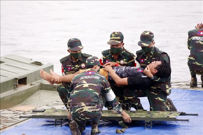Các chiến sĩ đang đưa một người dân đi cấp cứu trong một tình huống giả định tại diễn tập. Ảnh: Phạm Kiên/Phóng viên TTXVN tại Lào