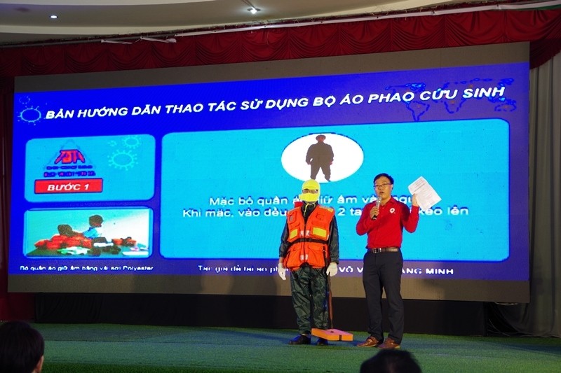 Ban tổ chức hướng dẫn ngư dân cách sử dụng bộ áo phao cứu sinh đa năng.