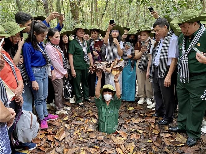 Đại biểu cùng sinh viên tham quan Khu Di tích Lịch sử Địa đạo Củ Chi (Ảnh: Hồng Giang/TTXVN).