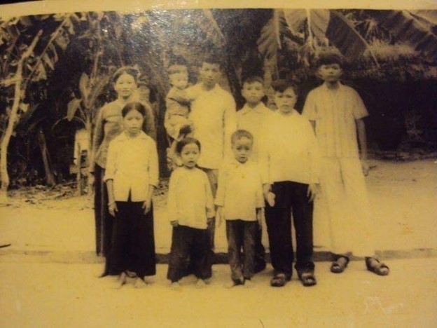 Trong ảnh: có mẹ Mai (bên trái, áo nâu, vấn tóc, hàng sau) đến bố Túc (thứ hai bên trái, áo trắng, bế em). (Ba người con đẻ nhỏ nhất, hàng đầu, bên trái). Ba con nuôi Lào (bên phải, hàng sau), người cao nhất bên phải là anh Bun Lặp, kế đó là anh Bun Phênh. Tôi đứng cạnh bố Túc, cũng là người con Lào nhỏ tuổi nhất của bố mẹ.