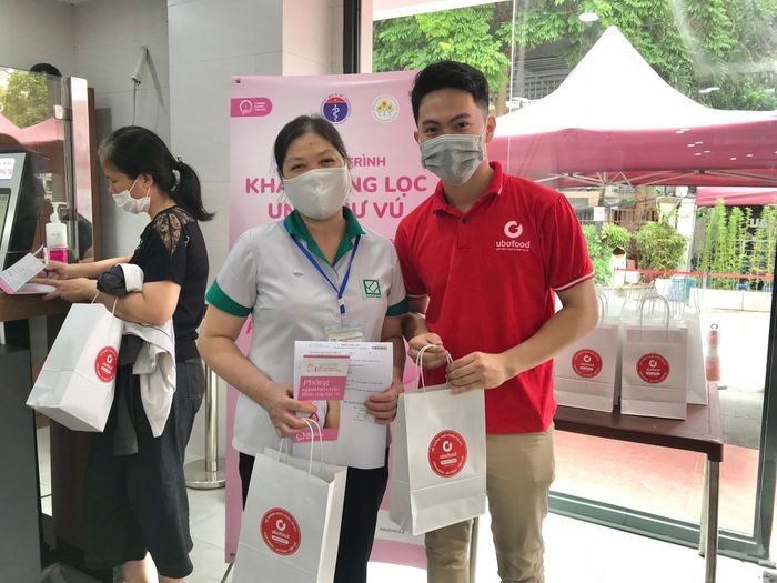 Đai diện Quỹ Ngày mai tươi sáng và nhà hảo tâm tặng quà cho người đến khám sàng lọc ung thư vú. (Ảnh: SK&ĐS)