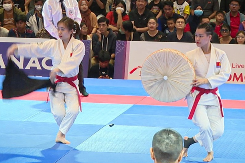 Hai cô gái Việt Nam mang nón quai thao, khăn mỏ quạ lên sàn đấu, ẵm luôn huy chương SEA Games 32