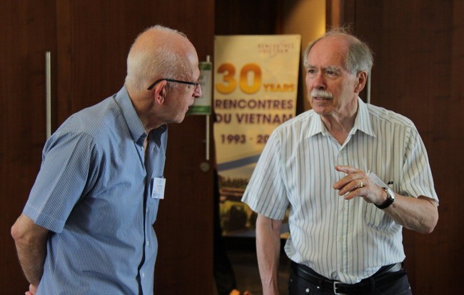GS Gerard 't Hooft (bên phải) trò chuyện với một nhà khoa học. 