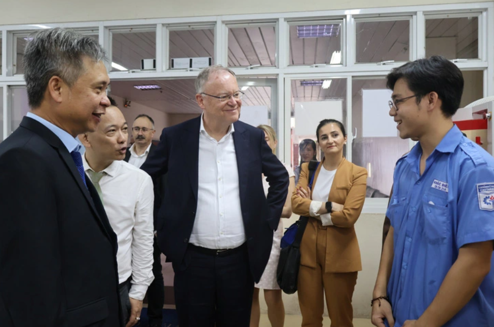 Thủ hiến Stephan Weil (giữa) và đoàn làm việc từ Đức gặp gỡ sinh viên Trường cao đẳng Kỹ thuật Cao Thắng tại xưởng thực hành