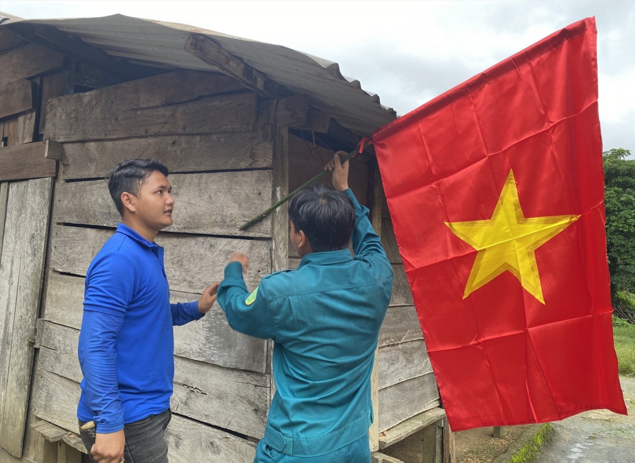 Hỗ trợ người dân cắm cờ Tổ quốc. Ảnh: Đ.N