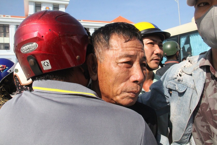 Ngư dân Phạm Văn Nga trở về trong vòng tay người thân nhưng thâm tâm ông vẫn hướng về phía biển nơi con rể Nguyễn Ngọc Pháp vẫn còn mất tích. (Ảnh: PLVN)