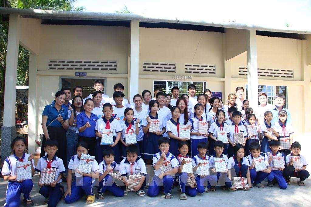 Các em học sinh chụp ảnh lưu niệm trước lớp học mới. (Ảnh: TTXVN)