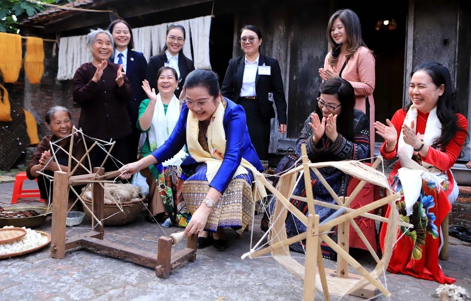 Bà Vandara Siphandone, phu nhân Thủ tướng Chính phủ Lào trực tiếp trải nghiệm công đoạn sản xuất lụa đũi. (Ảnh: TTXVN) Bà Vandara Siphandone, phu nhân Thủ tướng Chính phủ Lào trực tiếp trải nghiệm công đoạn sản xuất lụa đũi. (Ảnh: TTXVN)