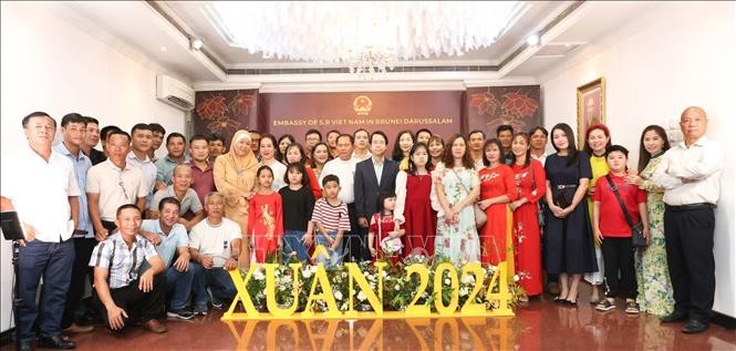 Đại sứ Việt Nam tại Brunei Darussalam Trần Anh Vũ chụp ảnh lưu niệm với cộng đồng kiều bào tại Brunei. (Ảnh: TTXVN phát)