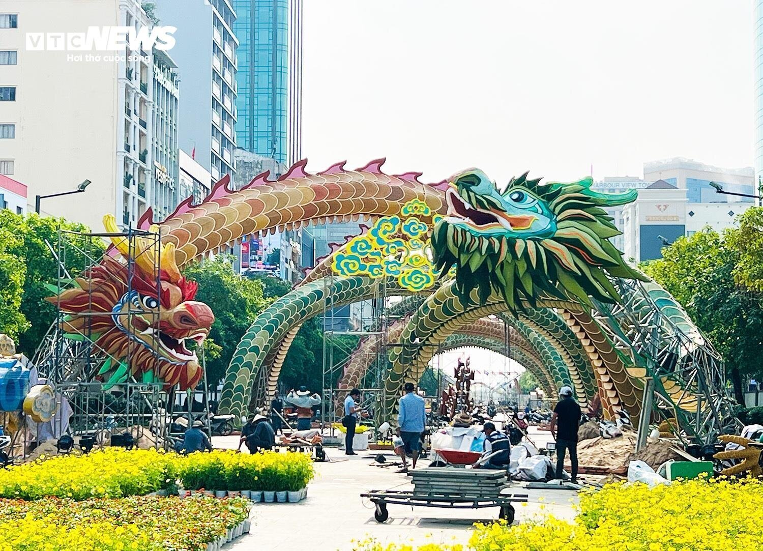 Ngay cổng vào của đường hoa Nguyễn Huệ (TP.HCM) là hai linh vật rồng lớn với tên gọi &quot;Lưỡng Long triều liên&quot; (đôi rồng chầu sen). Mỗi linh vật rồng dài khoảng 120m, lập kỷ lục về kích thước các linh vật xuất hiện trên đường hoa 21 năm qua. Thân rồng nhiều màu sắc rực rỡ, đan chéo vào nhau cao hơn 10m, tạo mái trần. Hai đầu rồng mang dáng vẻ uy nghi, kích thước vòng đầu khoảng 2m, cao hơn 3m so với mặt đất. Miệng rồng ngậm ngọc đường kính 50cm, bên trong chứa đèn thắp sáng. Bên trong cổ có lắp giàn âm thanh, bánh răng cửa để phát ra tiếng động và lắc lư chào du khách. Toàn thân rồng làm bằng kim loại phủ đèn Led. (Ảnh: Hoàng Thọ)
