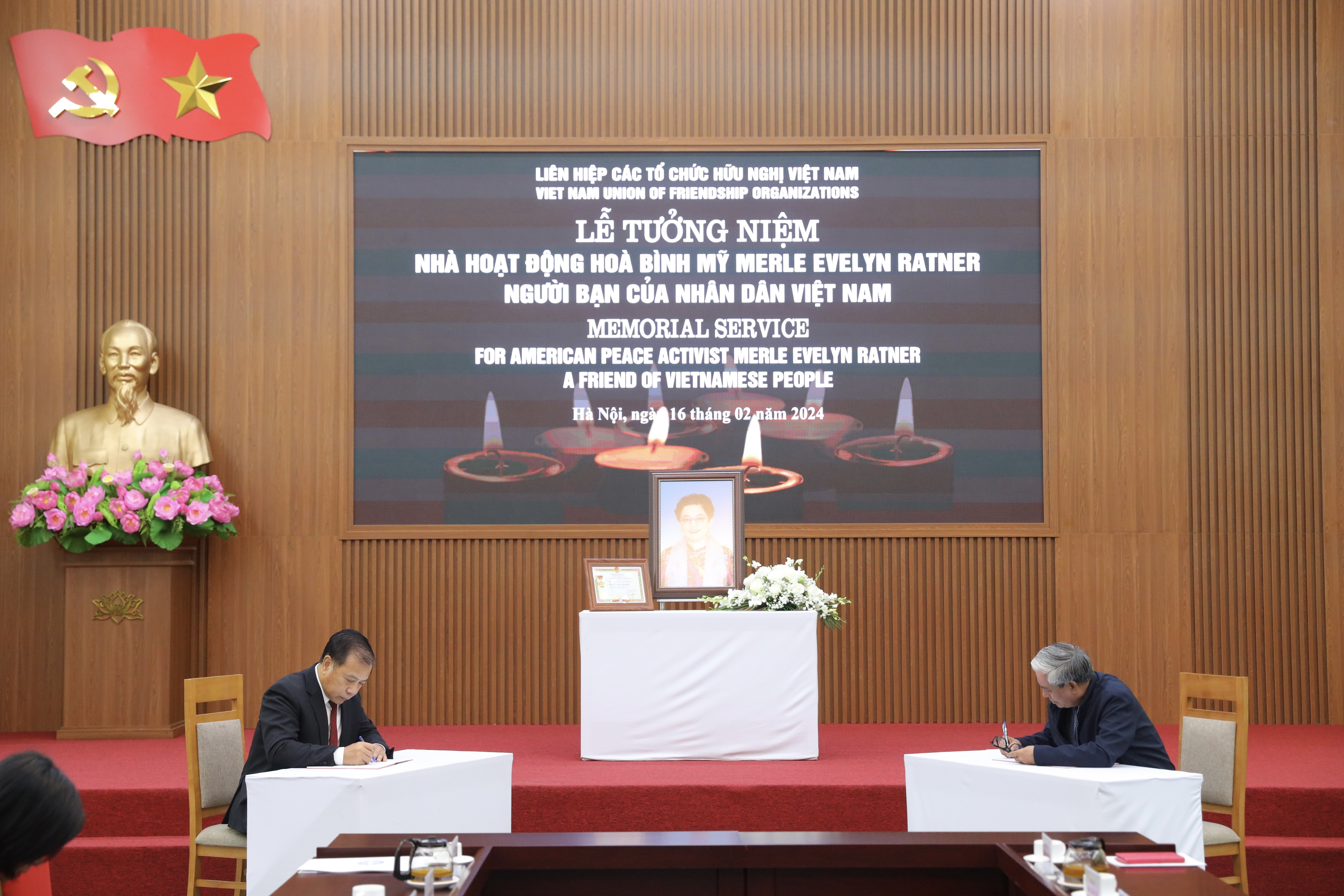  Đại sứ Phạm Quang Vinh (bìa phải) ghi sổ tang tiễn biệt bà Merle Ratner. (Ảnh: Đinh Hòa)