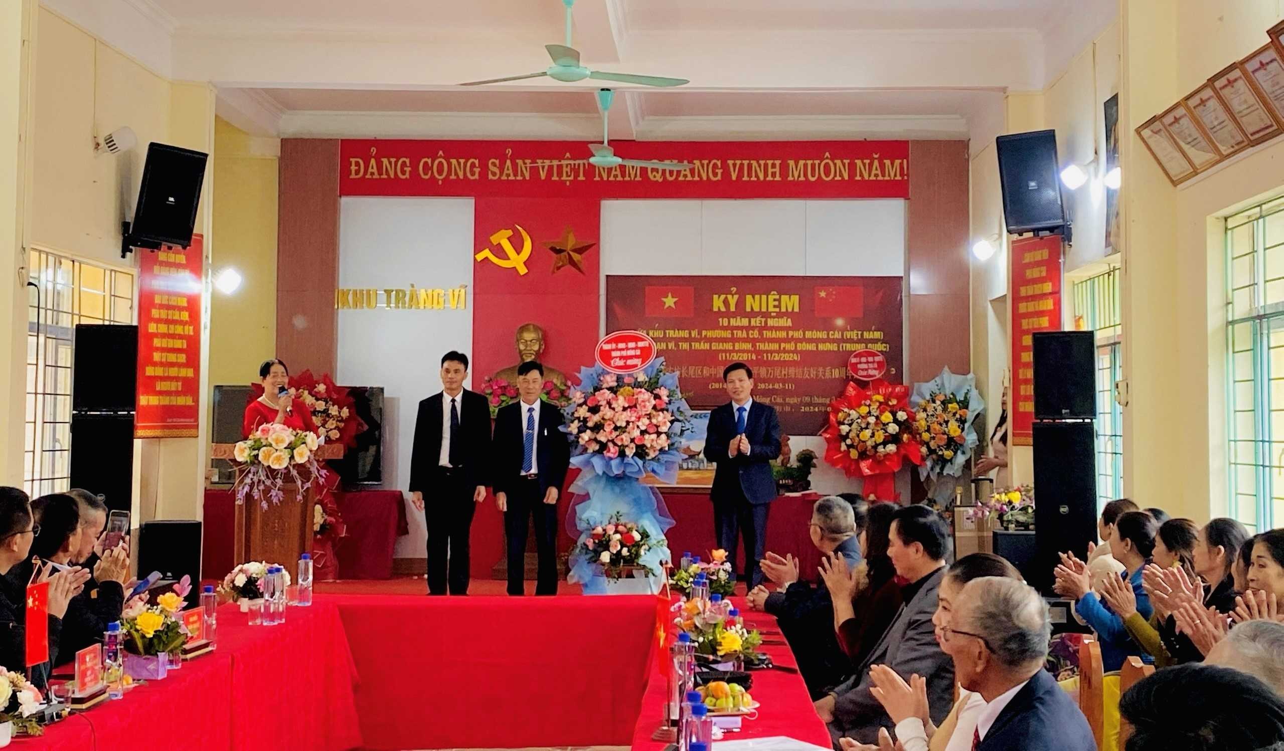 Đồng chí Đỗ Viết Mạnh, Ủy viên BTV Thành ủy, Trưởng Ban Dân vận Thành ủy, Chủ tịch Ủy ban MTTQ Thành phố Móng Cái (Việt Nam) tặng hoa chúc tình kết nghĩa 2 khu, thôn hai địa phương hai nước ngày càng phát huy 