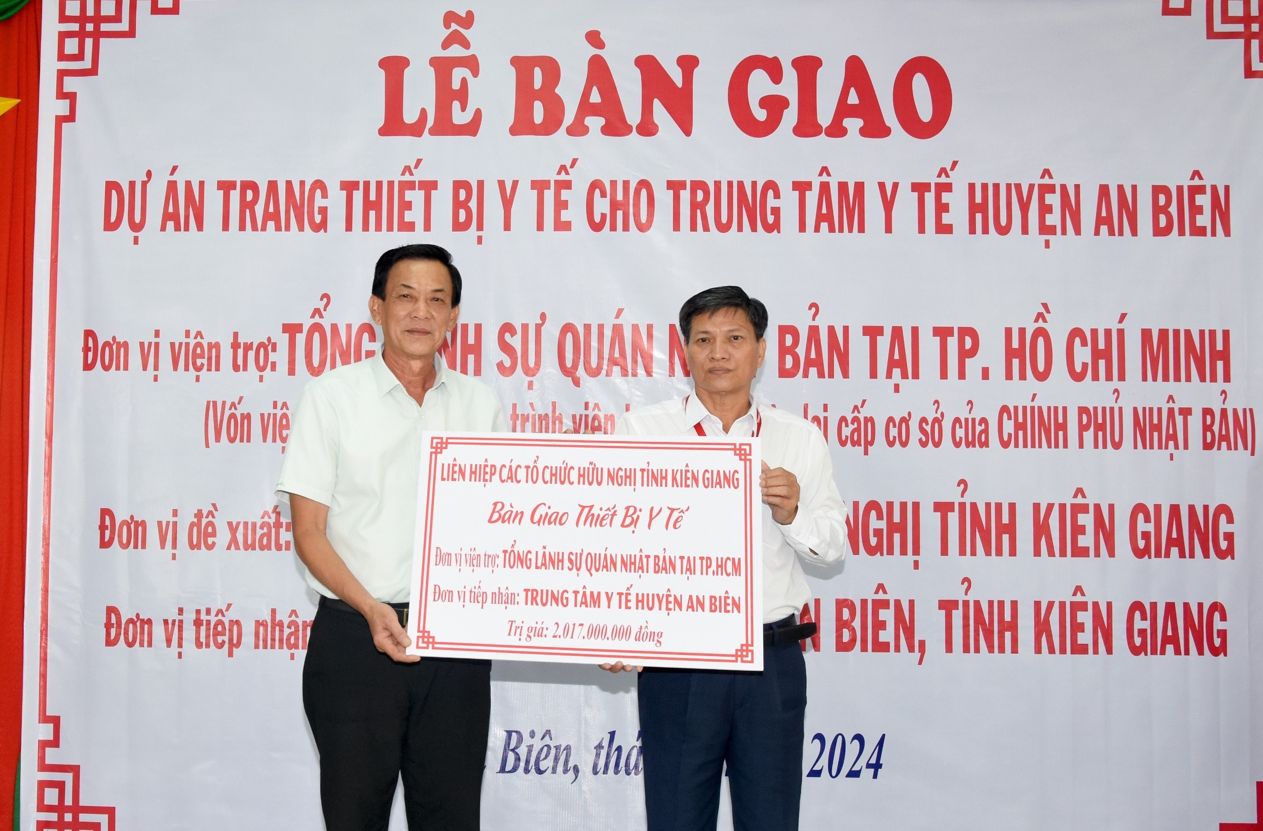 Chủ tịch Liên hiệp Các tổ chức hữu nghị tỉnh Kiên Giang Trần Chí Dũng (bìa trái) trao bảng tượng trưng cho Giám đốc Trung tâm Y tế huyện An Biên Huỳnh Đức Hòa (bìa phải).