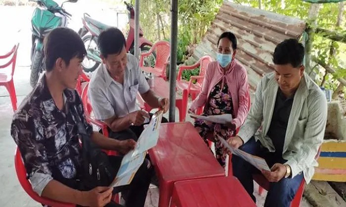 Ông Nguyễn Văn Sang (thứ hai từ trái sang) tuyên truyền chính sách BHXH, BHYT cho người dân (Ảnh: T.L). 