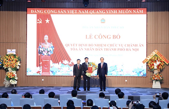 Chánh án Tòa án nhân dân tối cao Lê Minh Trí và Chủ tịch HĐND Thành phố Nguyễn Ngọc Tuấn trao Quyết định và tặng hoa chúc mừng ông Nguyễn Xuân Kỳ (Ảnh: T.L).
