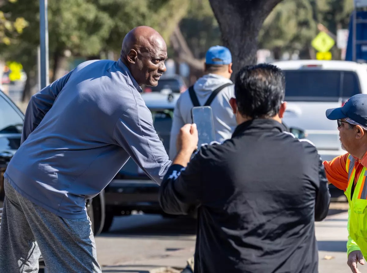 Huấn luyện viên đội bóng rổ Los Angeles Lakerss, Michael Cooper (bên trái), chào đón các tình nguyện viên và người dân mang đồ quyên góp đến một địa điểm tập trung lớn bên ngoài Rose Bowl. (Ảnh: Los Angeles Times)