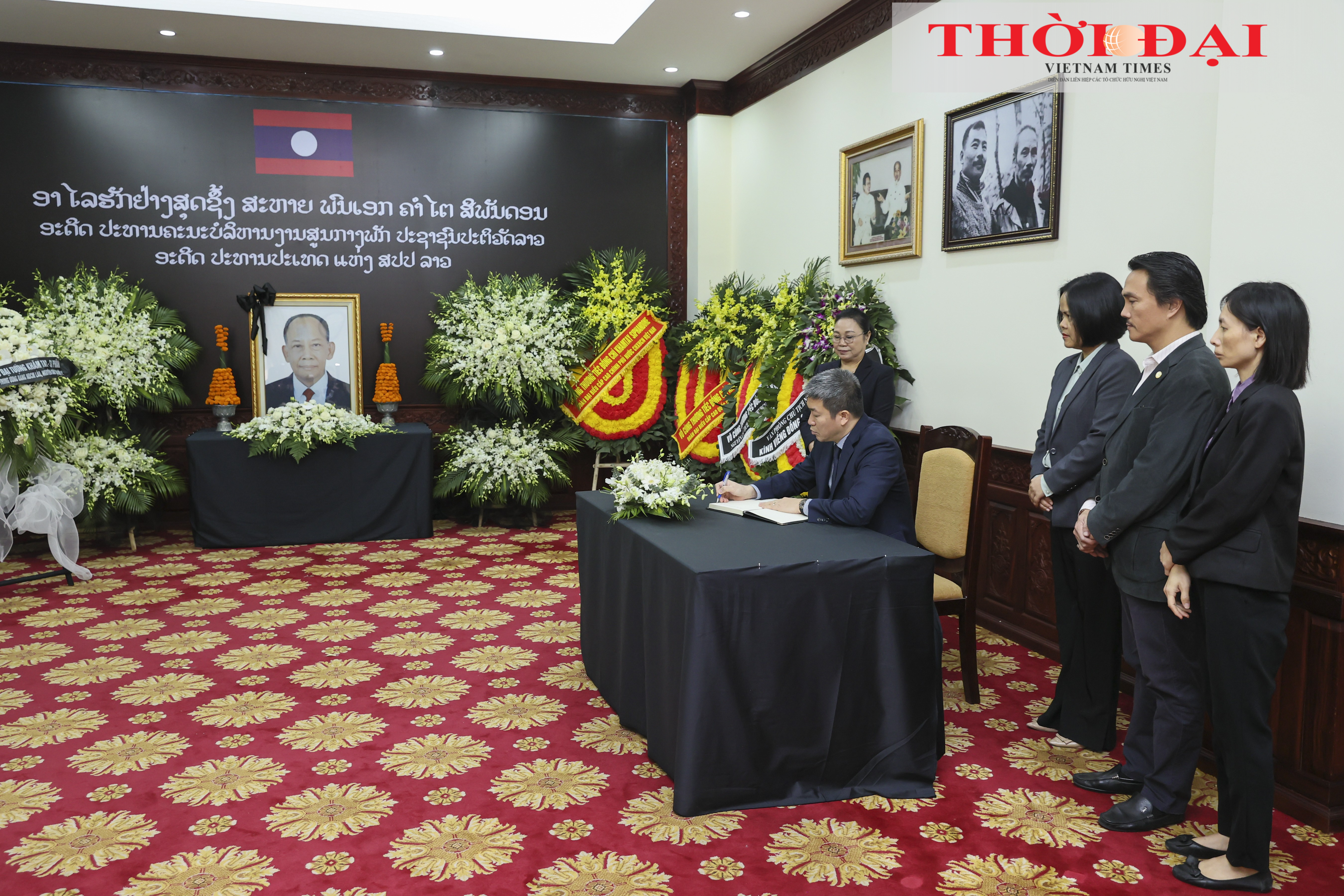 Ông Phan Anh Sơn ghi sổ tang tưởng niệm Đại tướng Khamtay Siphandone. (Ảnh: Đinh Hòa)