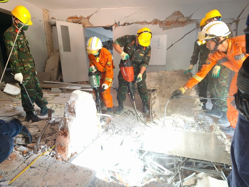 Đội công binh của đoàn QĐND Việt Nam và lực lượng cứu hộ của Myanmar, UAE đục bê tông để mở lối xuống tiếp cận vị trí các nạn nhân bị vùi lấp.