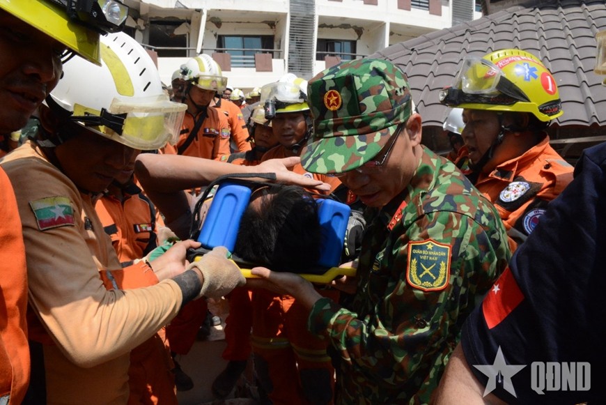  Lực lượng cứu hộ của Việt Nam, Myanmar và Thổ Nhĩ Kỳ đưa nạn nhân ra xe cứu thương.
