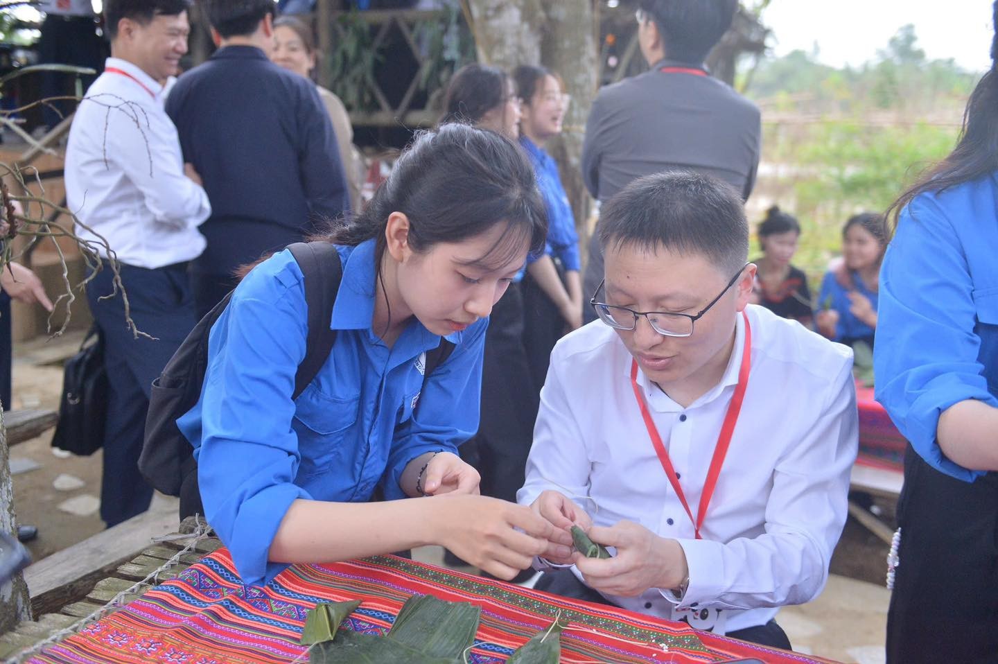 Tình nguyện viên Việt Nam hướng dẫn đại biểu thanh niên Trung Quốc gói bánh. (Ảnh: doanthanhnien.vn) Tình nguyện viên Việt Nam hướng dẫn đại biểu thanh niên Trung Quốc gói bánh. (Ảnh: doanthanhnien.vn)