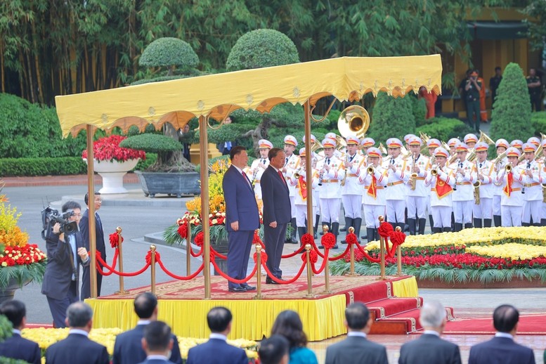 Trong tiếng nhạc chào mừng, Tổng Bí thư Tô Lâm mời Tổng Bí thư, Chủ tịch nước Trung Quốc Tập Cận Bình bước lên bục danh dự. (Ảnh: Báo Chính phủ)
