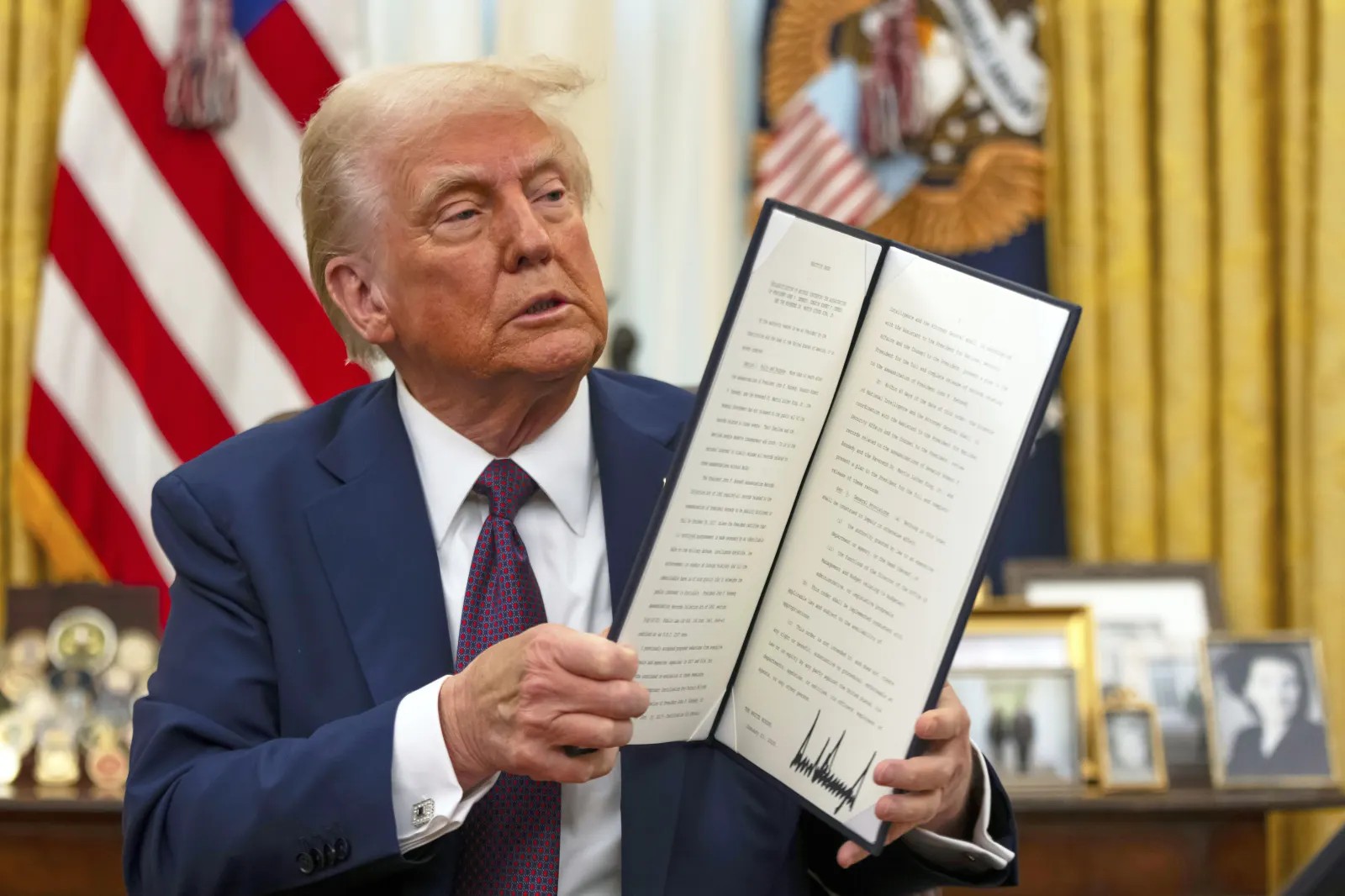 Tổng thống Donald Trump cầm một sắc lệnh hành pháp đã ký nhằm giải mật hồ sơ liên bang về các vụ ám sát Tổng thống John F. Kennedy, Thượng nghị sĩ Robert F. Kennedy và Martin Luther King Jr., tại Phòng Bầu dục của Nhà Trắng, ngày 23/1/2025. (Ảnh: AP)