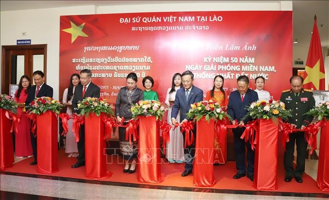 Các đại biểu tham dự cắt băng Khai mạc Triển lãm ảnh. (Ảnh: Xuân TTXVN)