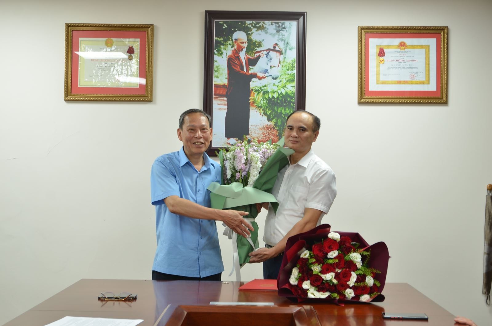 Nguyên Tổng Biên tập Nguyễn Anh Tuấn chúc mừng tân Tổng Biên tập Lê Văn Thơm. (Ảnh: 