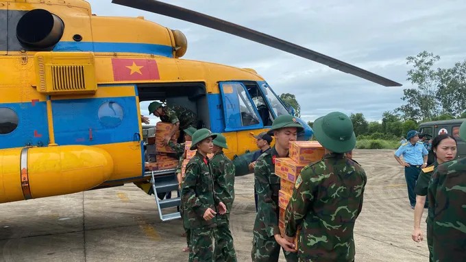 Cán bộ, chiến sĩ vận chuyển hàng cứu trợ lên trực thăng. (Ảnh: Báo Sài Gòn Giải Phóng)