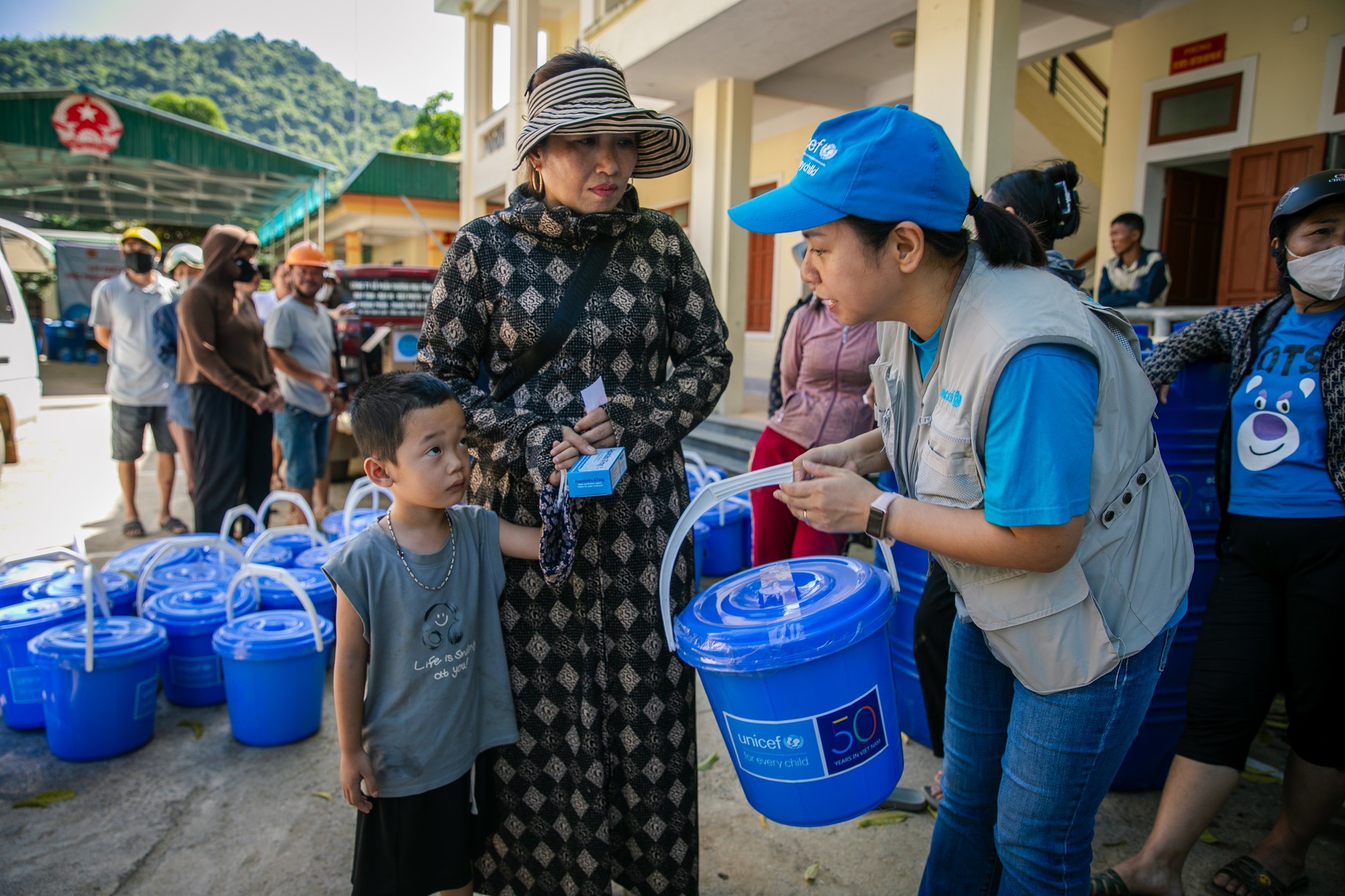 Cán bộ của UNICEF với người dân ở vùng bị ảnh hưởng bởi lũ lụt, sạt lở đất do hoàn lưu của bão số 3. (Ảnh UNICEF)