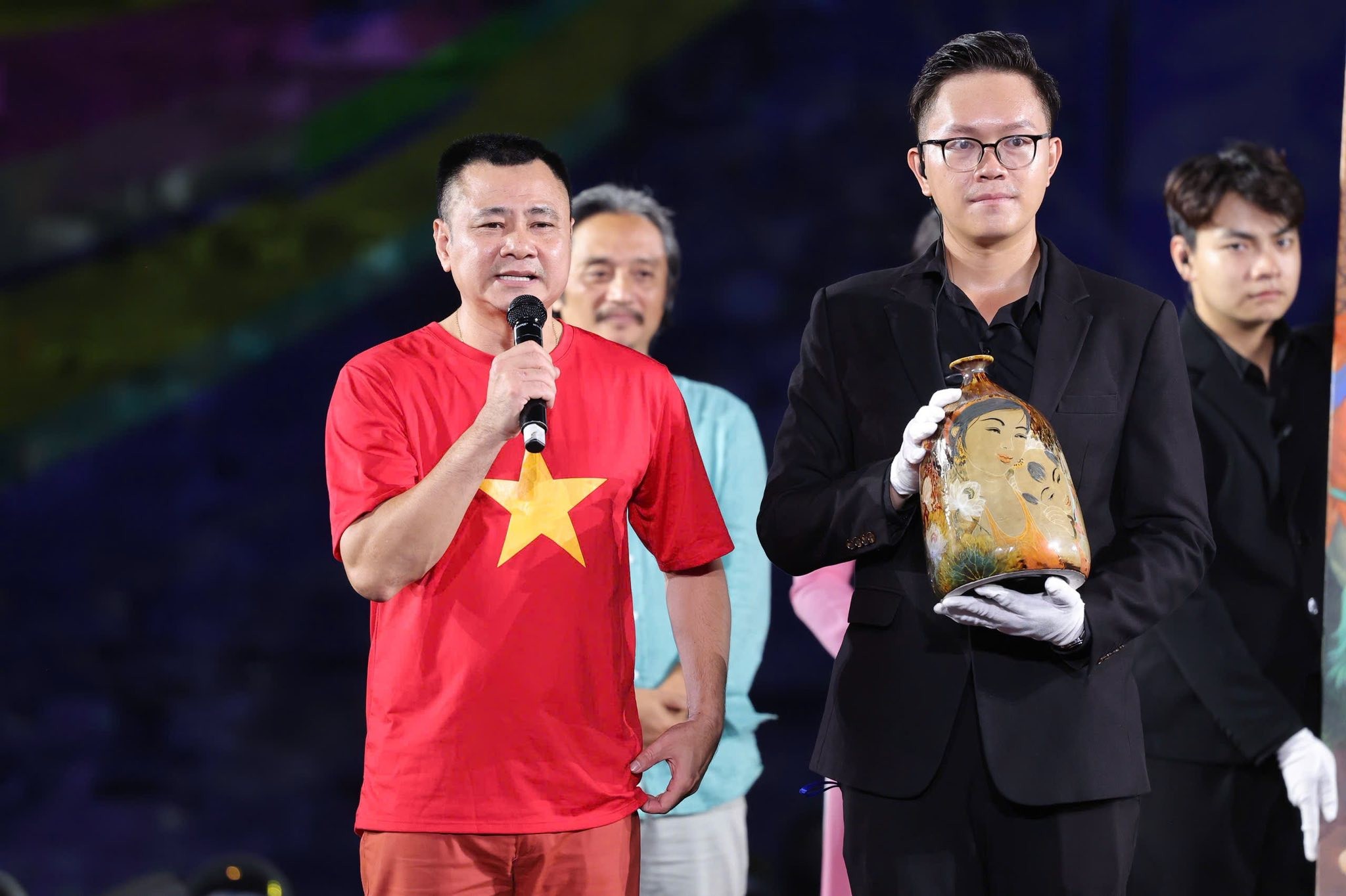 Nghệ sỹ Nhân dân Tự Long tham gia dẫn dắt phiên đấu giá, trong hình là hai vật phẩm đấu giá thành công 1,55 tỷ đồng.