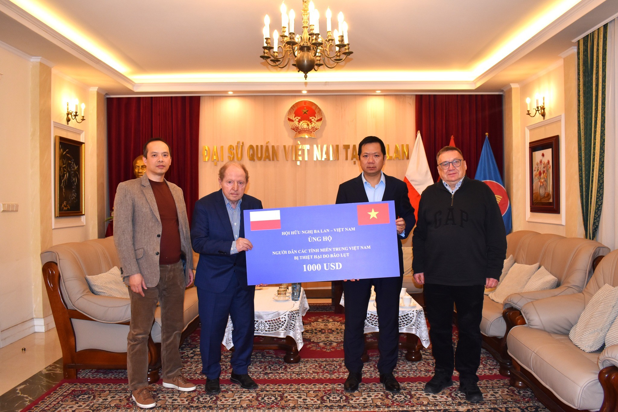 Đại sứ Việt Nam tại Ba Lan Hà Hoàng Hải tiếp nhận số tiền ủng hộ đồng bào vùng thiên tai từ Giáo sư Tadeusz Iwinski, Chủ tịch Hội hữu nghị Ba Lan - Việt Nam. (Ảnh: Đại sứ quán Việt Nam tại Ba Lan)