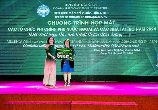 Phó Chủ tịch Liên hiệp các tổ chức hữu nghị tỉnh Đồng Nai, bà Vy Vũ Hồng Thảo, tiếp nhận bảng tượng trưng tài trợ của tổ chức WWO/Hoa Kỳ. (Ảnh: dufo.dongnai.gov.vn)