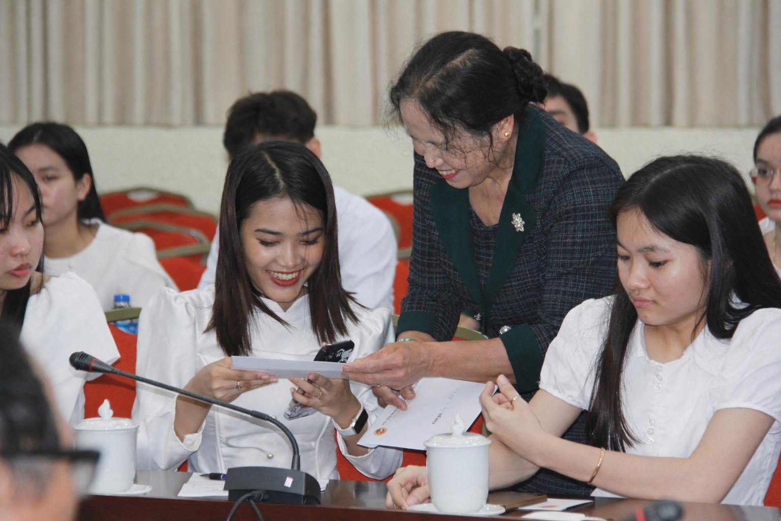 Bà Sơn Thị Bích, Ủy viên Ban Chấp hành Hội hữu nghị Việt Nam - Campuchia Chùa Tháp và các con đỡ đầu trao đổi địa chỉ liên hệ. (Ảnh: Thành Luân)