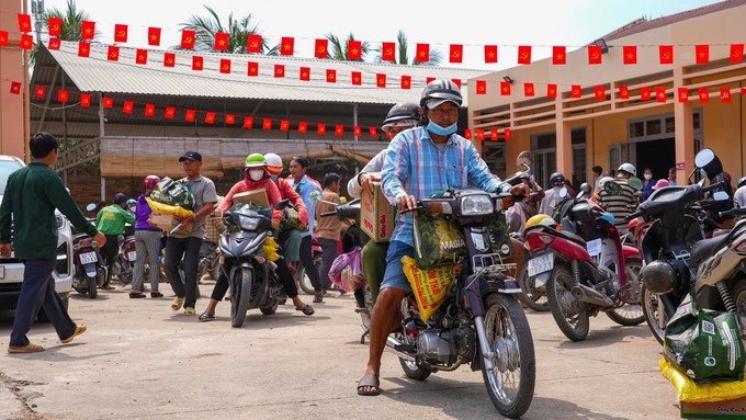 Người khuyết tật, người yếu thế trên địa bàn xã Mỹ Quý chở quà Tết gồm gạo, bánh mứt và nhu yếu phẩm về nhà.