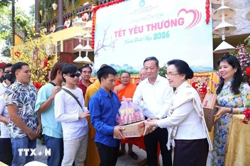 Phu nhân Tổng Bí thư, Chủ tịch nước Lào Naly Sisoulith và Đại sứ Việt Nam tại Lào Nguyễn Minh Tâm trao phần quà yêu thương đầu tiên cho người khuyết tật. (Nguồn: TTXVN)