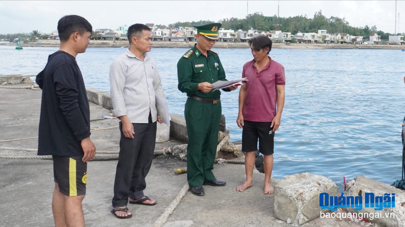 Cán bộ Trạm Kiểm soát Biên phòng Sa Kỳ kiểm tra danh sách thuyền viên trước khi cho tàu xuất bến. (Ảnh: Báo Quảng Ngãi)