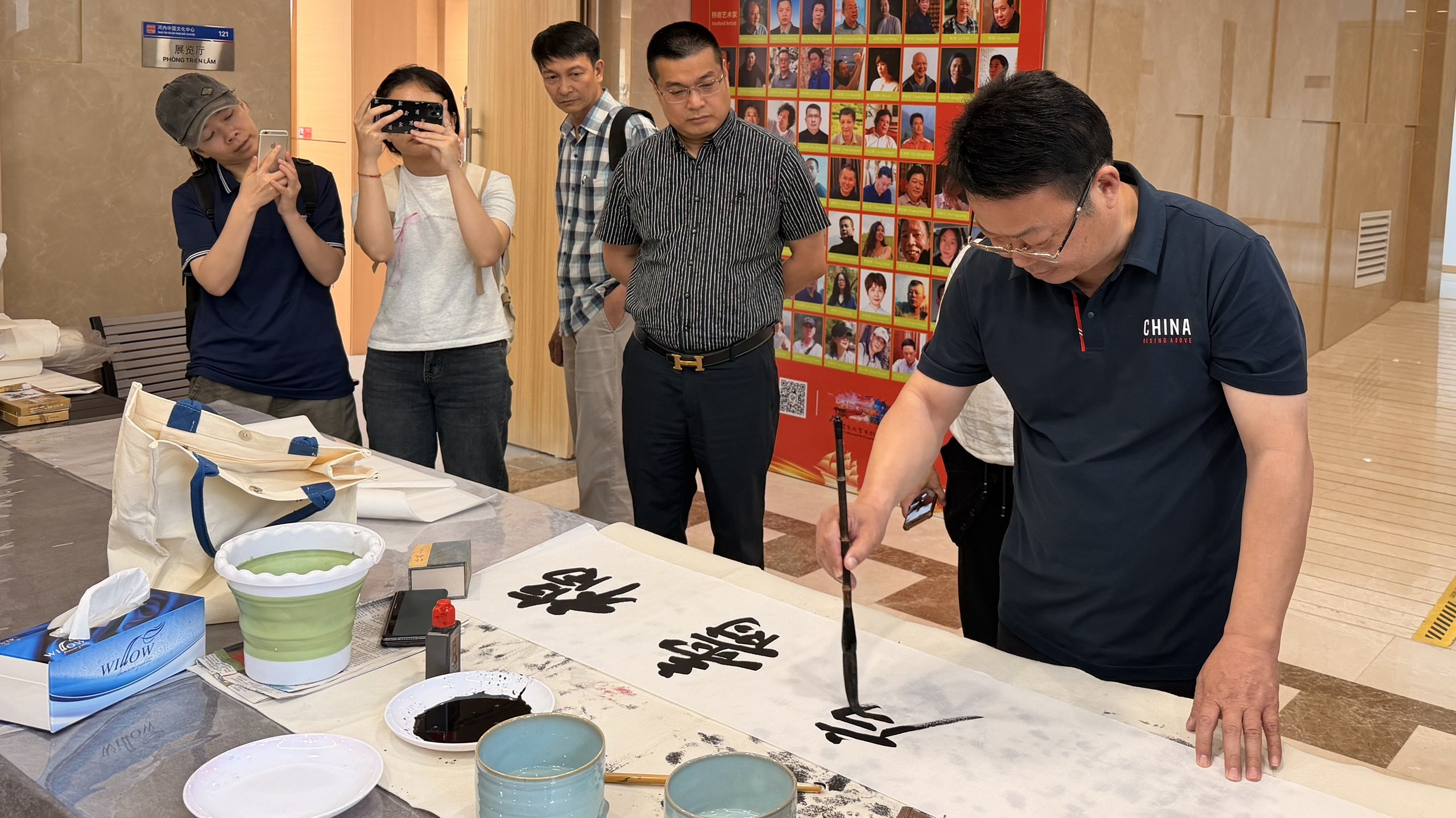 Nghệ sĩ giao lưu, viết thư pháp tại Triển lãm. Nghệ sĩ giao lưu, viết thư pháp tại Triển lãm.