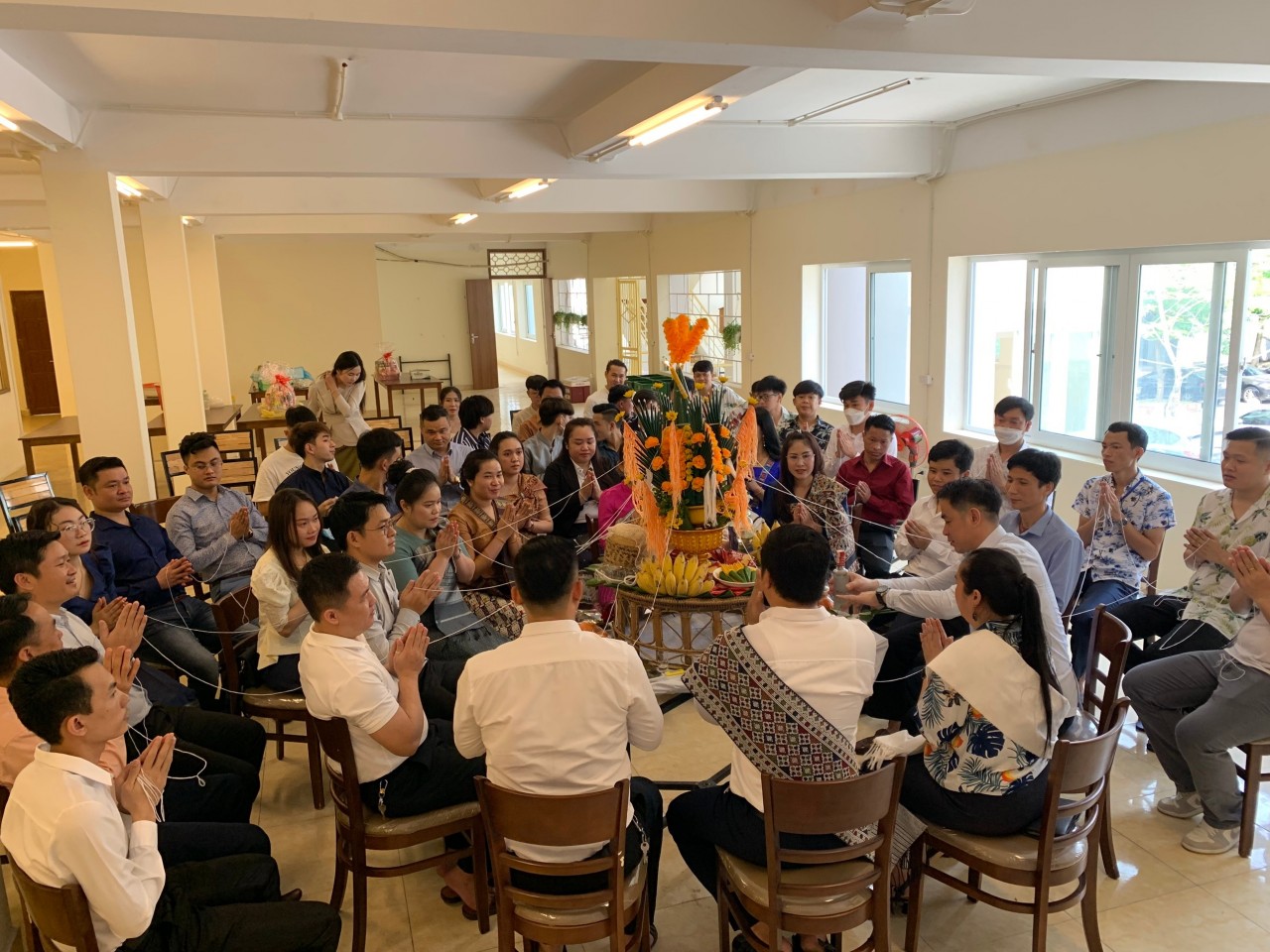 Các đại biểu và LHS Lào đã cùng tham dự những nghi lễ truyền thống của Tết Bunpimay buộc chỉ cổ tay.