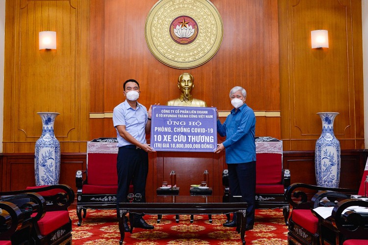 Ông Đỗ Văn Chiến, Chủ tịch Ủy ban Trung ương MTTQ Việt Nam, tiếp nhận bảng tượng trưng ủng hộ 10 xe Hyundai Solati cứu thương từ ông Lê Ngọc Đức, Tổng Giám đốc Liên doanh Ô tô Hyundai Thành Công Việt Nam.