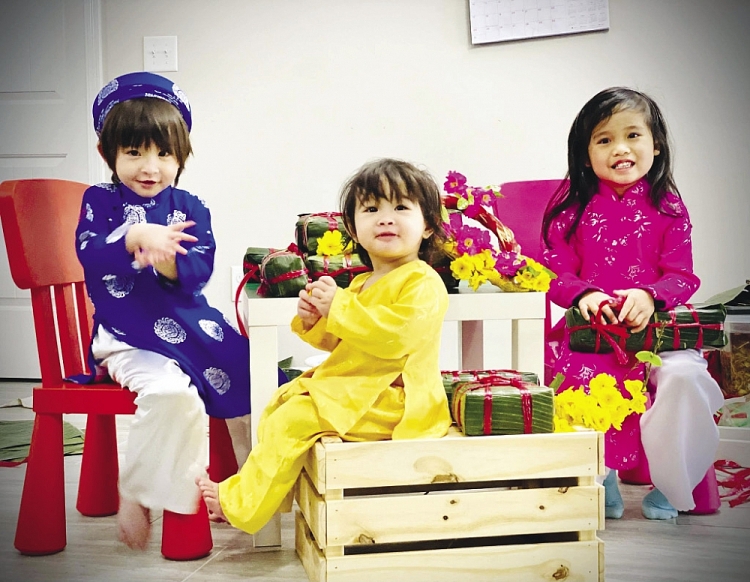 Các em nhỏ phụ ông bà gói bánh.