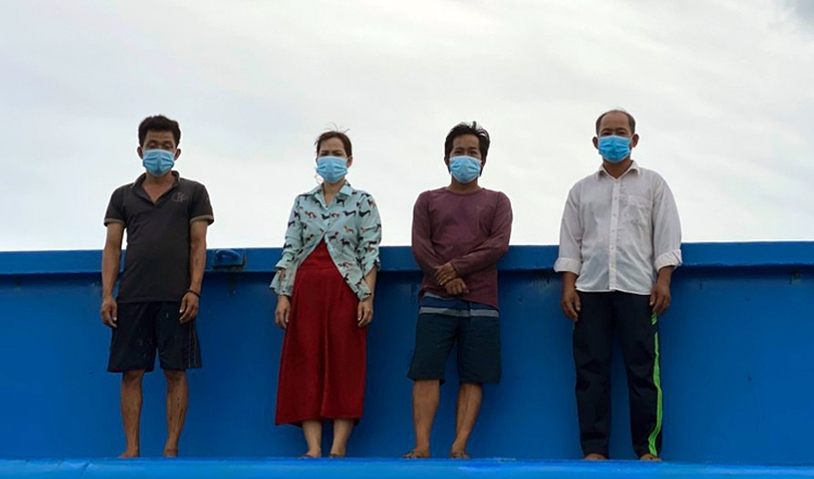 Ông Tân (bìa phải) cùng 3 người khác trên sà lan khi bị lực lượng biên phòng phát hiện. Ảnh: Vinh Tiến