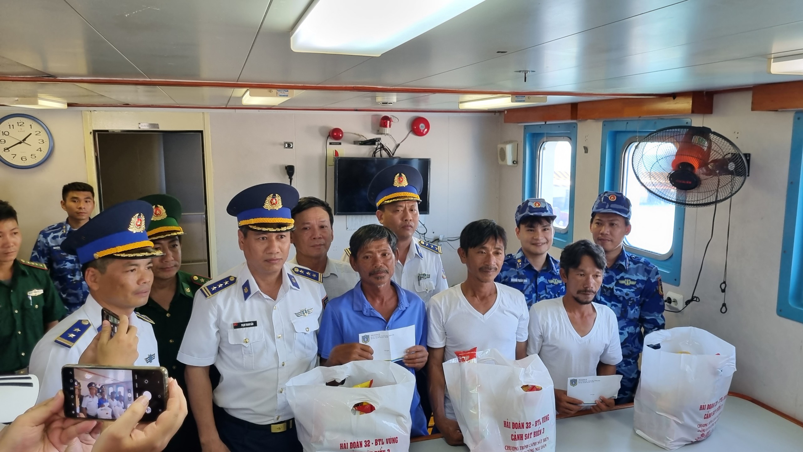 Lực lượng Cảnh s&amp;aacute;t biển v&amp;agrave; ch&amp;iacute;nh quyền địa phương tặng qu&amp;agrave; hỗ trợ c&amp;aacute;c ngư d&amp;acirc;n may mắn tho&amp;aacute;t nạn. Ảnh: Trung Vũ.