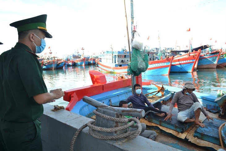 Cán bộ Đồn Biên phòng Lý Sơn tuyên truyền, vận động ngư dân đi cách ly tập trung. Ảnh: Hữu Danh