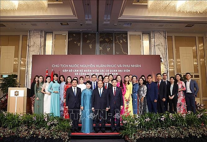 Chủ tịch nước Nguyễn Xuân Phúc và Phu nhân chụp ảnh chung với cán bộ, nhân viên Đại sứ quán và đại diện cộng đồng người Việt Nam tại Singapore. Ảnh: Thống Nhất/TTXVN.